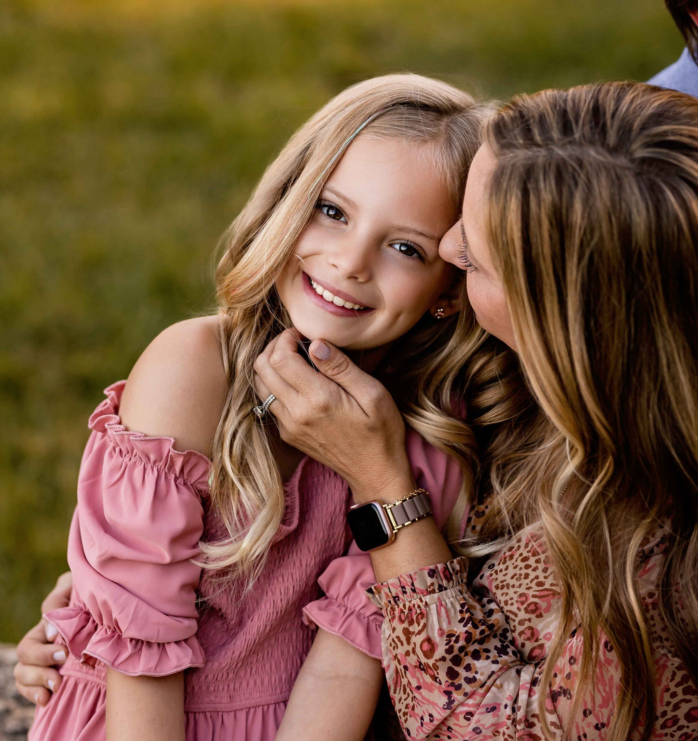 Happy daughter embracing with mother, enjoying a family moment in a natural, sunlit environment