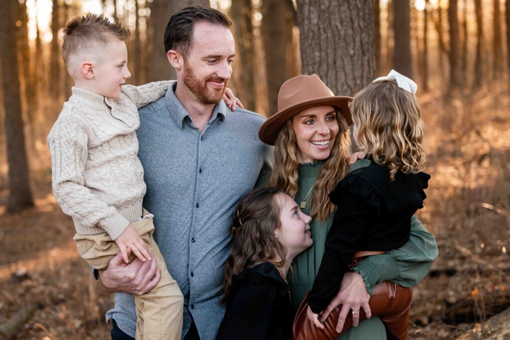 A happy family in a pine forest at a St. Louis, Missouri photo session. 