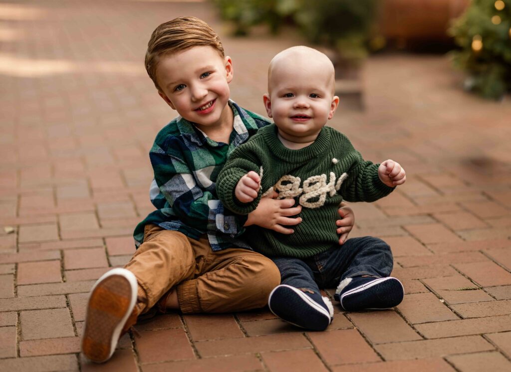 Two small kids snuggle in for a sweet family photo at the St. Louis Botanical Garden.