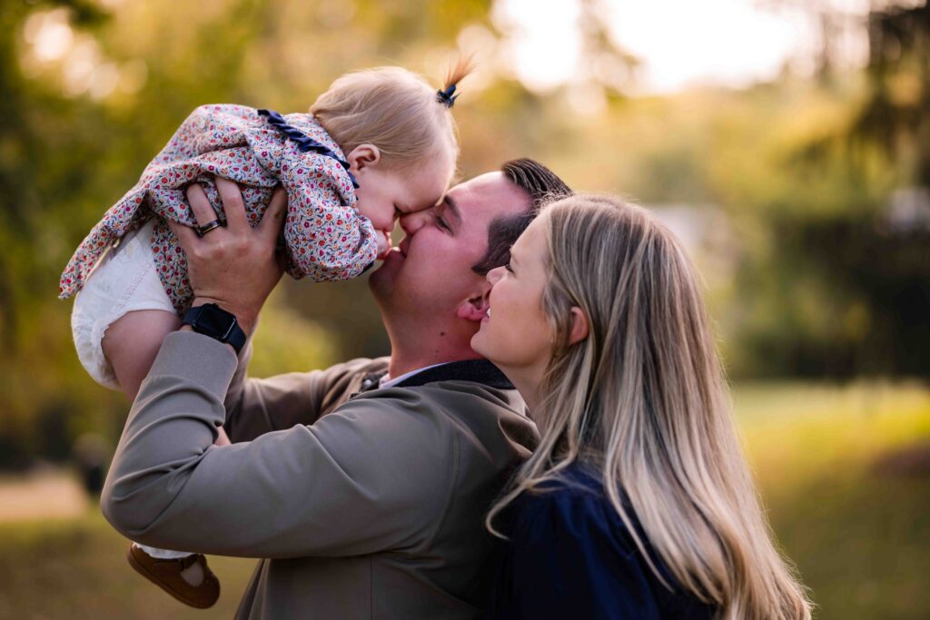 Father lifting his toddler into the air.